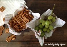 grapes and waffles in paper bags on a wooden table