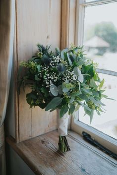 a bouquet of flowers sitting on top of a window sill