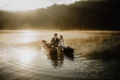 a man and woman sitting in a boat on the water