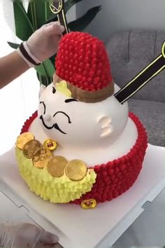 a cake made to look like a snowman wearing a hat and scarf with gold coins on it