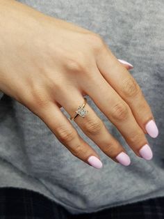 a woman's hand with pink manicured nails and a diamond ring