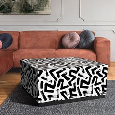 a living room with a brown couch and black and white pattern on the table top