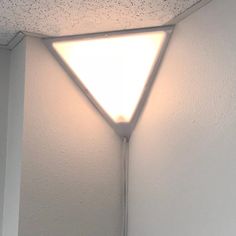 a light that is on the side of a wall in a room with white walls