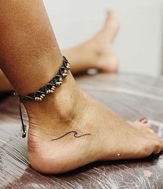 a woman's foot with a small tattoo on the side of her left ankle