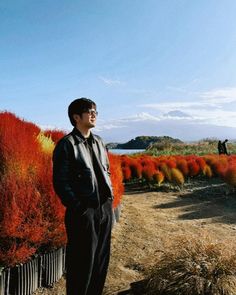 a man standing in front of some colorful plants