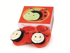 a pair of red baby shoes with ladybugs on them in front of a box