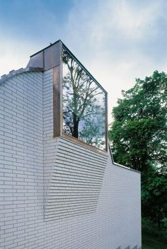 a white brick building with a tree in the window