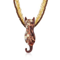 a necklace with beads and a cat head on the front, hanging from it's side