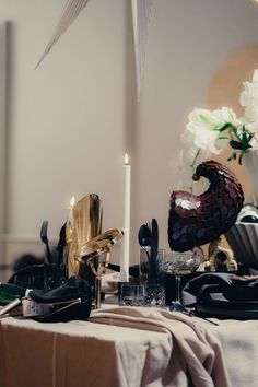 the table is set with black and white plates, silverware, candles and flowers