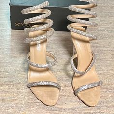 Size 9.5. Comes With Box. Only Walked With At The Store And Never Worn After. Silver Blingy And Beige Silver Glitter Sandals For Party Season, Silver Sandals For Prom And Party Season, Silver Chic Sandals For Party Season, Chic Silver Sandals For Party Season, Silver Sandals With Wrapped Heel For Night Out, Silver Sandals With Wrapped Heel For Party, Silver Sandals For Party Season, Champagne Color Sandals For Summer Party, Glamorous Metallic Sandals For Party