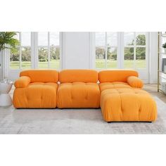 an orange couch sitting in front of two windows