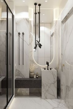 an elegant bathroom with marble walls and flooring, along with black fixtures in the shower area