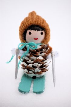 a doll holding a pine cone with a knife in it