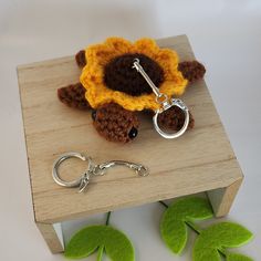 a crocheted keychain with a flower on it sitting on top of a wooden table