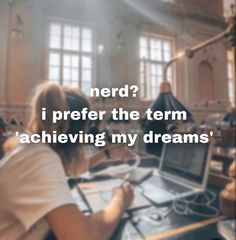 a person sitting at a desk with a laptop in front of them and the words nerd? i prefer the term achieving my dreams