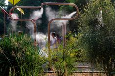 two people are standing in front of some steam rising out of the pipes and into the water