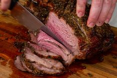 a person cutting meat with a large knife