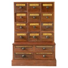 an old wooden cabinet with many drawers and brass letters on it's sides,