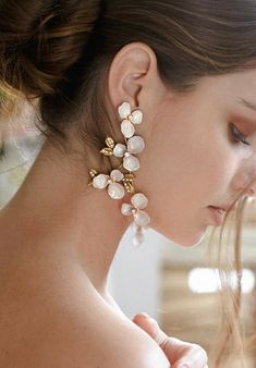 a close up of a person wearing some kind of earring with flowers on it