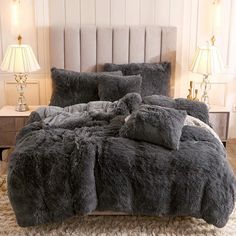 the bed is made with grey fur and has two lamps on either side of it