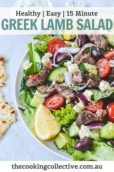 greek style lamb salad with feta cheese and lemon wedges on the side in a white bowl