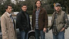 three men standing in front of a car