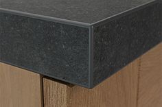 a close up view of the top of a wooden cabinet with black paint on it