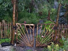 the gate is made out of bamboo and has many plants growing on top of it