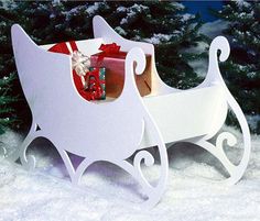 a white sleigh with presents in it sitting in the snow