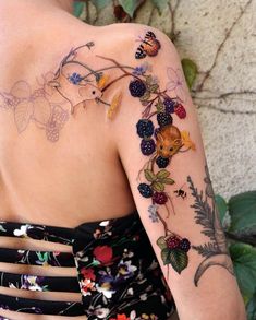 the back of a woman's shoulder with flowers and butterflies on it