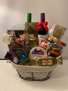 a wine and gourmet gift basket on a table