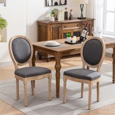 a dining room table with two chairs next to it