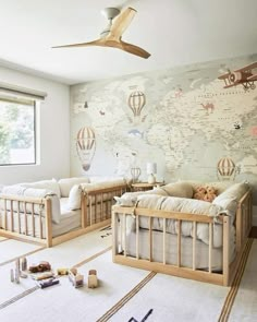 a baby's room with two cribs and a map on the wall