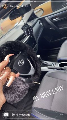 a woman is holding up her phone while sitting in the driver's seat of a car