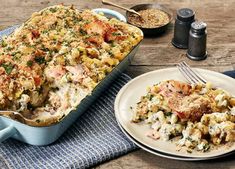 a casserole dish with meat and vegetables on a table next to a fork