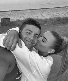 a man and woman kissing each other on the beach