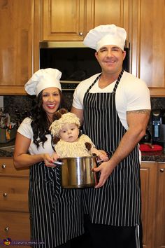 a man and woman are holding a baby in a pot while wearing chef's hats