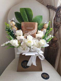 a vase filled with white flowers and chocolates