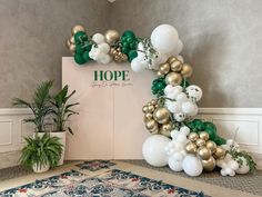 balloons and greenery decorate the entrance to a room with a sign that says hope