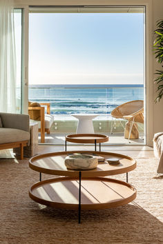 a living room filled with furniture and a large window overlooking the ocean in front of it