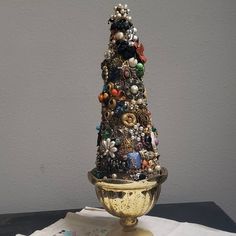 there is a very small christmas tree made out of beads and other things on the table