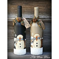 two wine bottles are decorated with snowmen