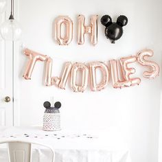 a table with balloons that say oh noodles and minnie mouse ears on it