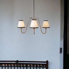 a chandelier with three lamps hanging from it