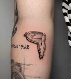 a close up of a person's leg with a clock tattoo on the side