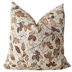 a brown and white pillow with leaves on it