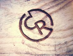 a close up of a wooden surface with the letter g in it's center