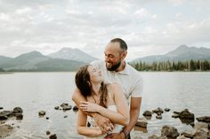 a man and woman embracing each other by the water