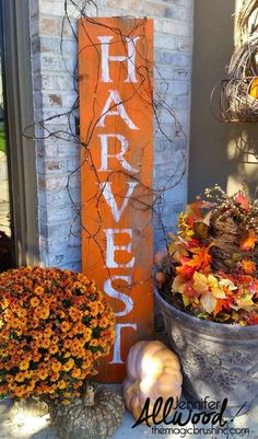 some pumpkins and gourds are sitting on the front porch next to a sign that says harvest