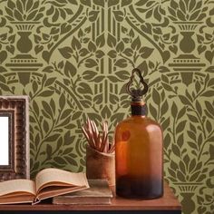 an open book sitting on top of a wooden table next to a vase and mirror